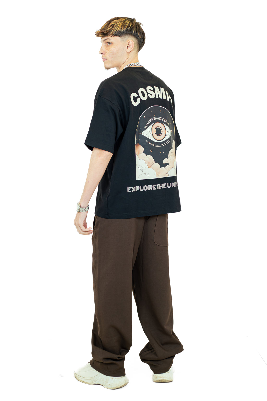 Person wearing a black t-shirt with 'Cosmik' design on the back, standing against a white background