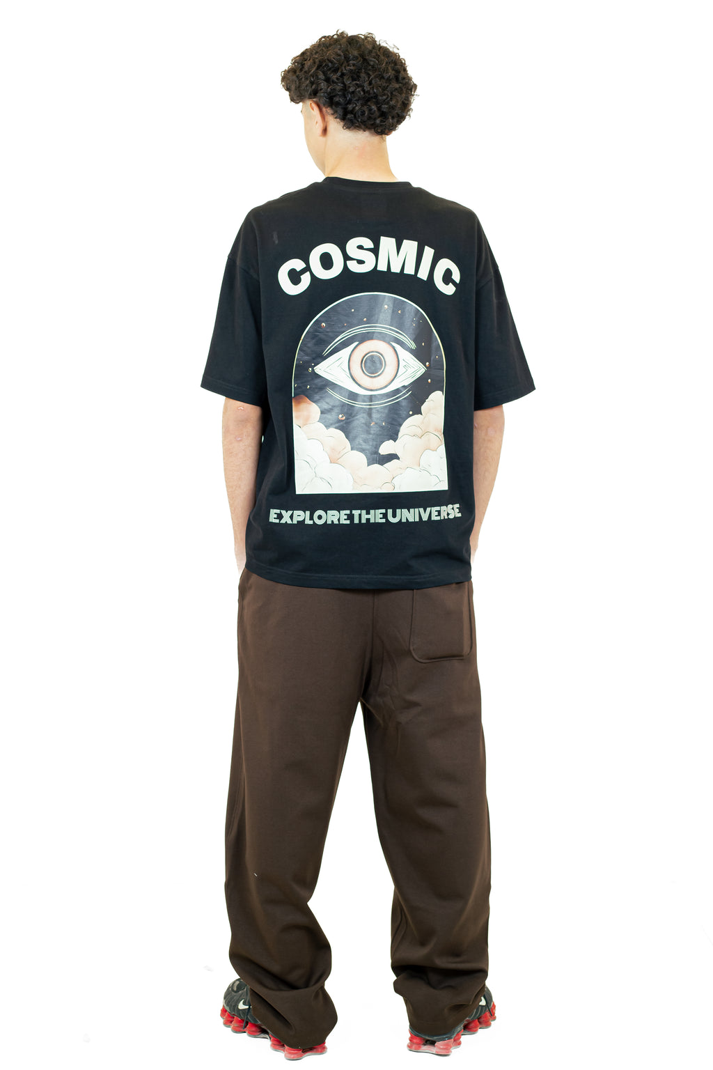 Person wearing a black t-shirt with 'Cosmic' and 'Explore the Universe' design on the back.