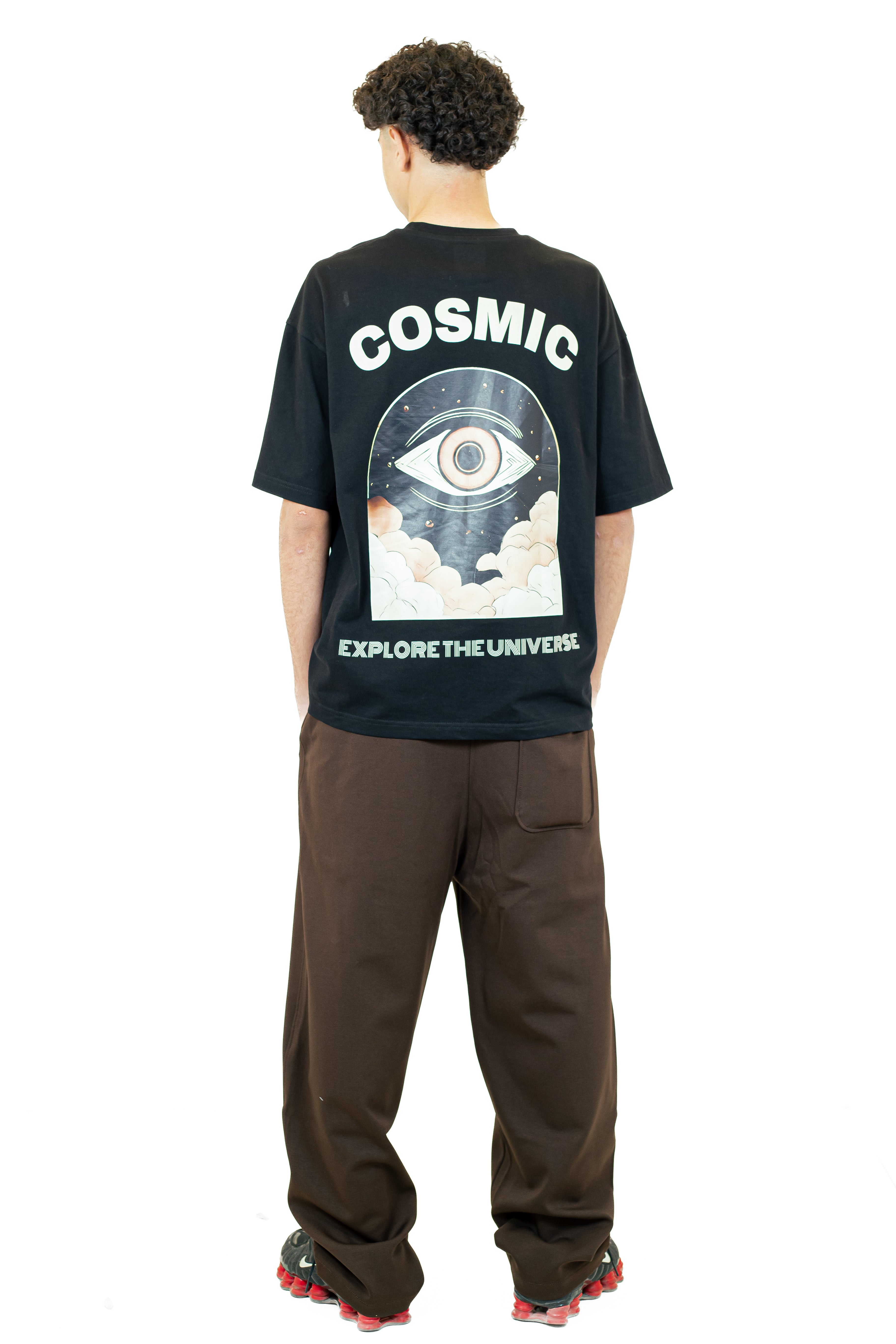 Person wearing a black t-shirt with 'Cosmic' and 'Explore the Universe' design on the back.